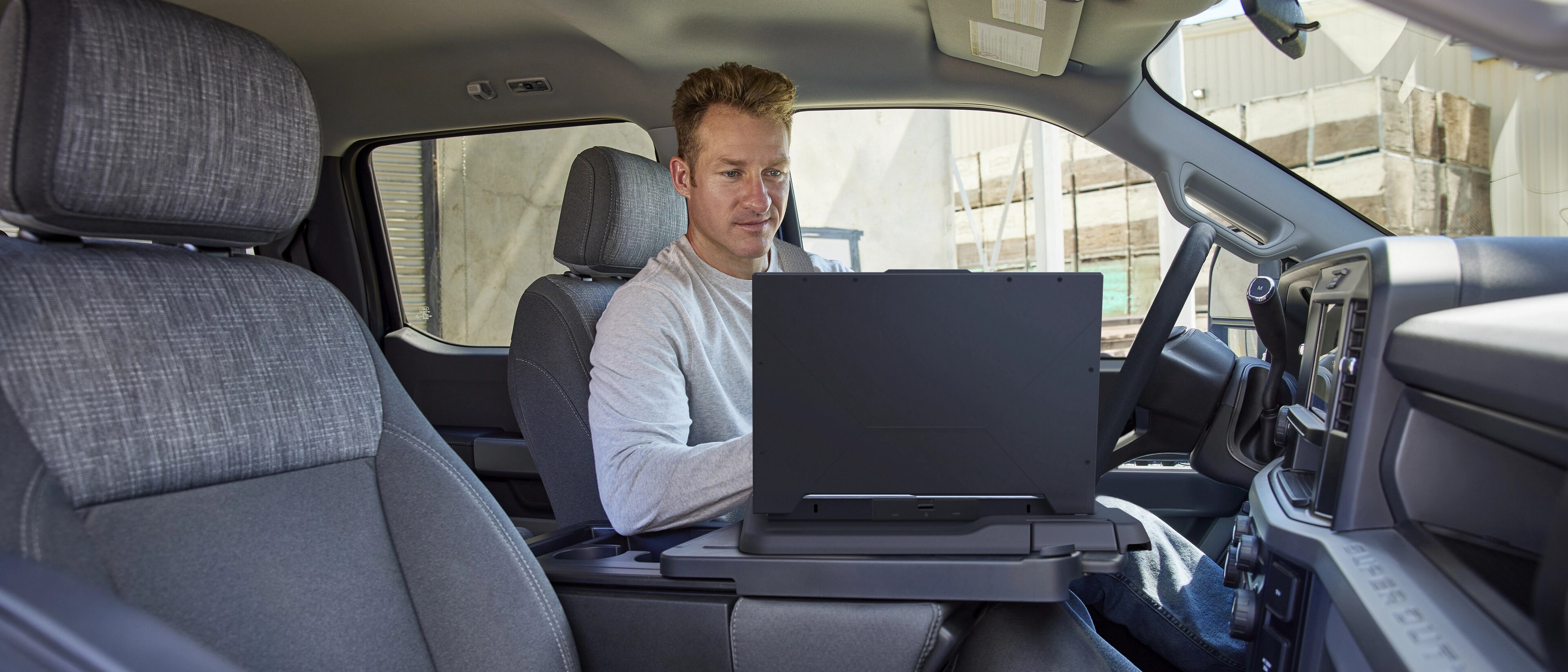 Une personne travaillant sur un ordinateur portable utilisant la surface de travail intérieure à l’intérieur de l’habitacle de son camion Ford Super Duty® 2026