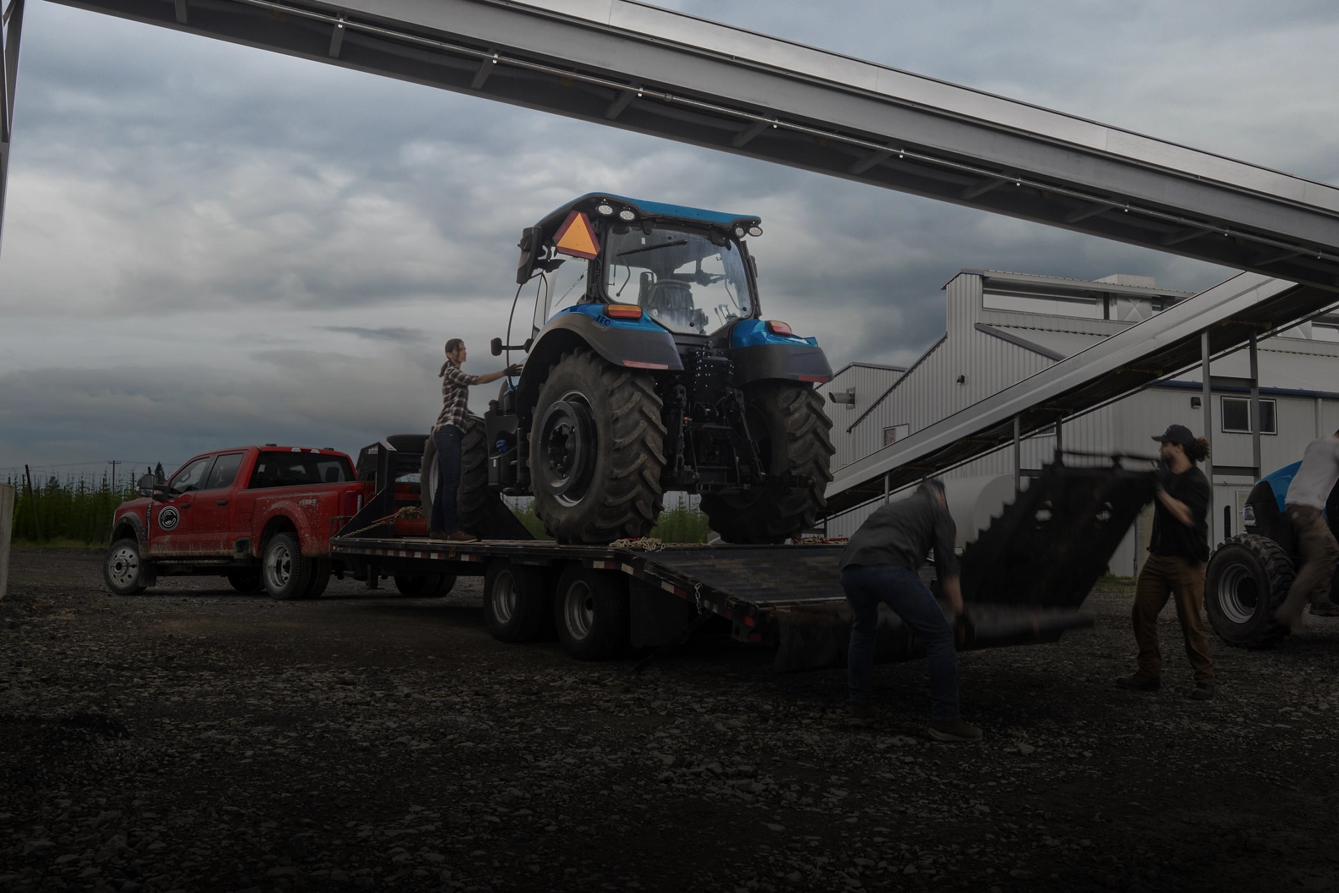 Ford Super Duty® F-450® XL 2026 en rouge course tirant une remorque transportant un gros tracteur