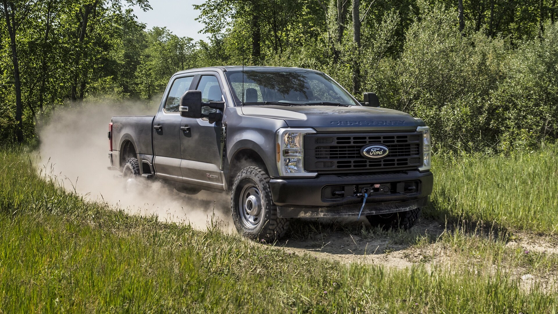 Modèle Ford Super Duty® F-250® XL 2026 en gris carbonisé tirant une caravane sur une route pavée