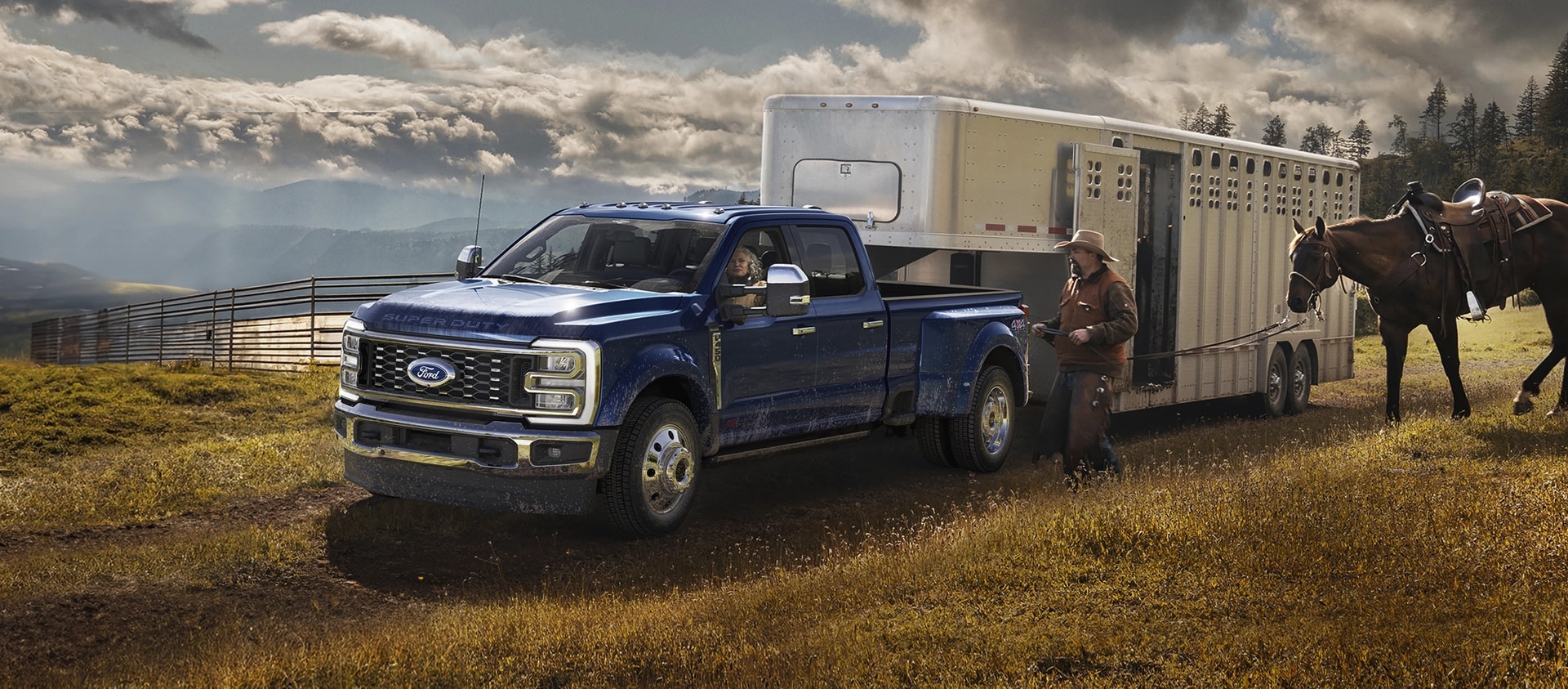 Ford Super Duty® F-450® King Ranch® 2026 couleur bleu argon remorquant un transporteur de chevaux sur une ferme herbeuse