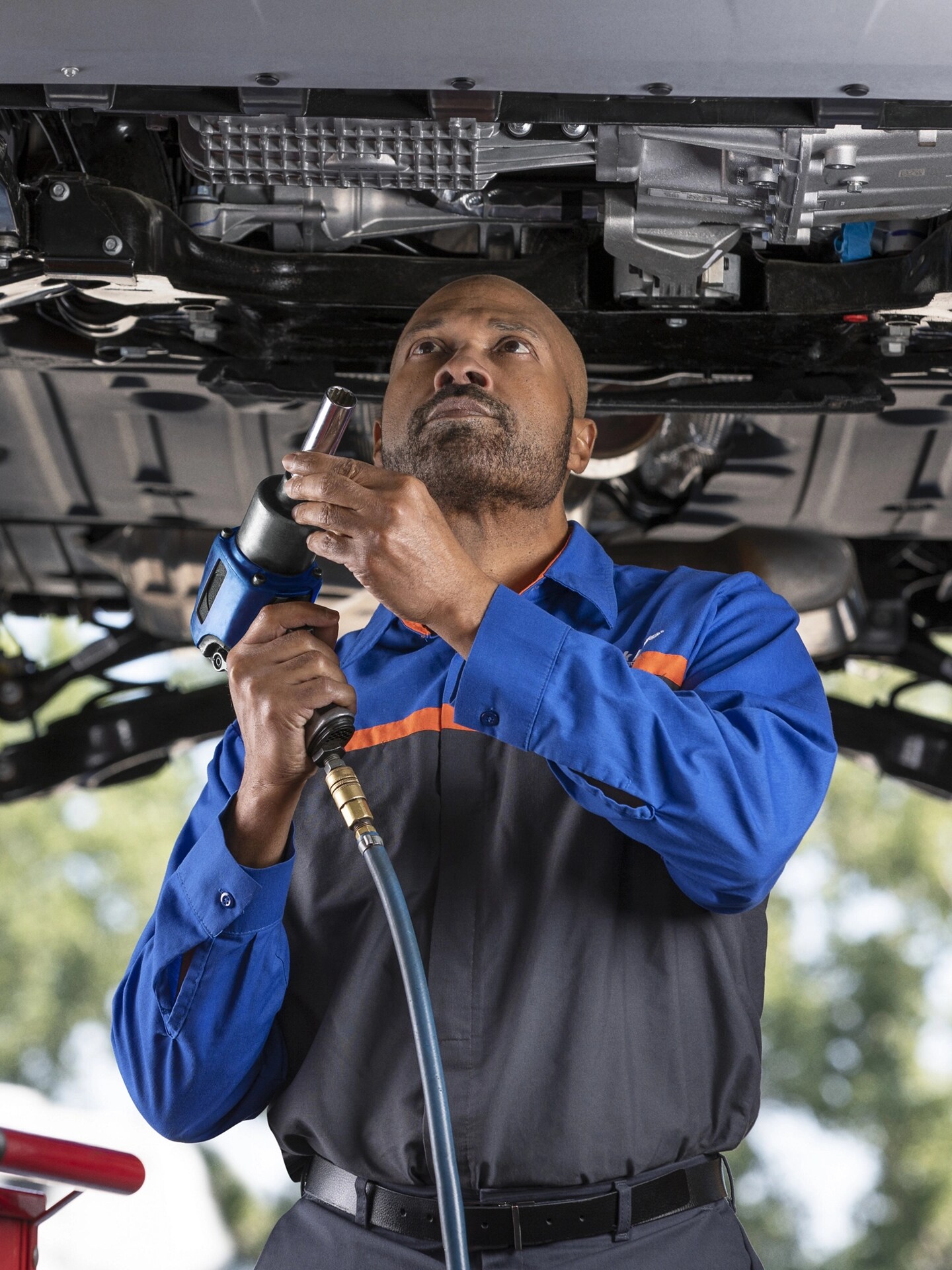 Un garage Service technique Ford avec un homme entretenant un véhicule Ford