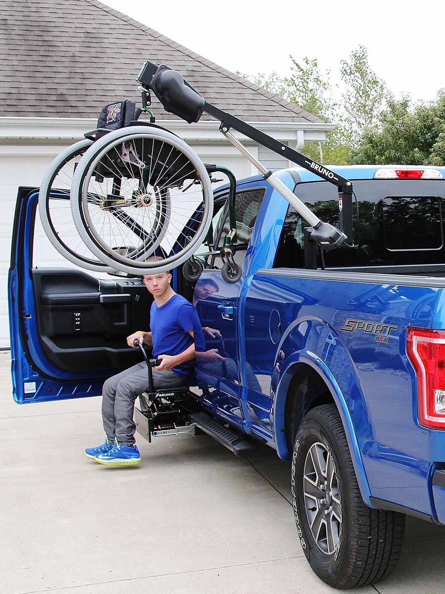 Un F-150 bleu avec un palan de fauteuil roulant dans la caisse