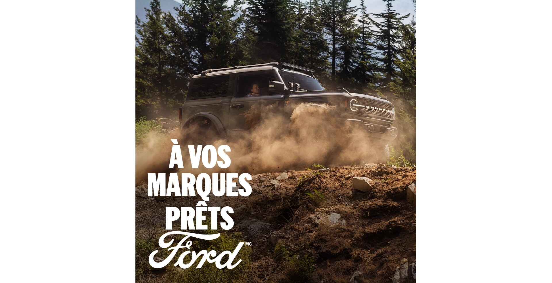 Un VUS Ford Bronco® 2026 roulant sur un sentier forestier boueux, avec la légende « Prêt, partez, Ford. » superposée.