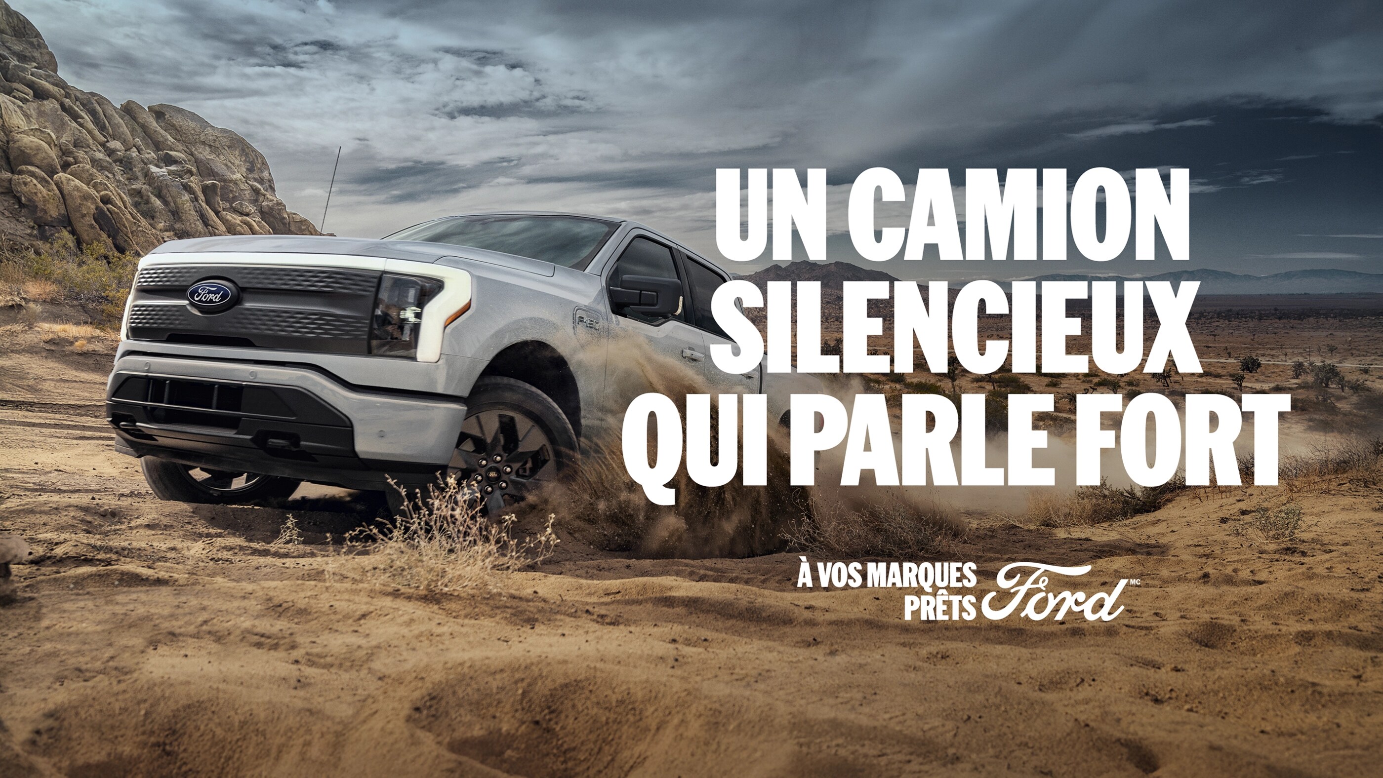 Profil aérien d'un Ford F 150 Lightning blanc roulant hors route sur un terrain dégagé. Un camion silencieux qui parle fort. À vos marques, prêts, Ford.