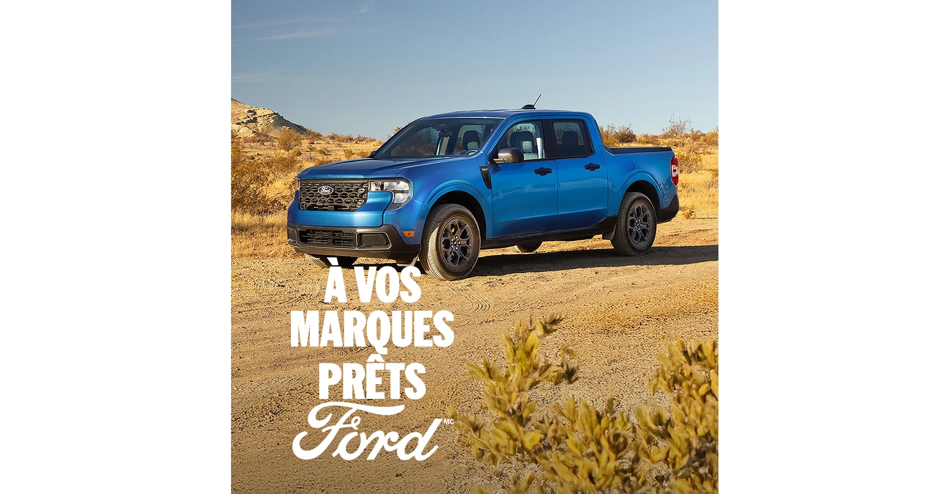 Vue de trois quarts avant d'un Ford Maverick bleu garé sur une route de terre dans le désert. À vos marques, prêts, Ford.
