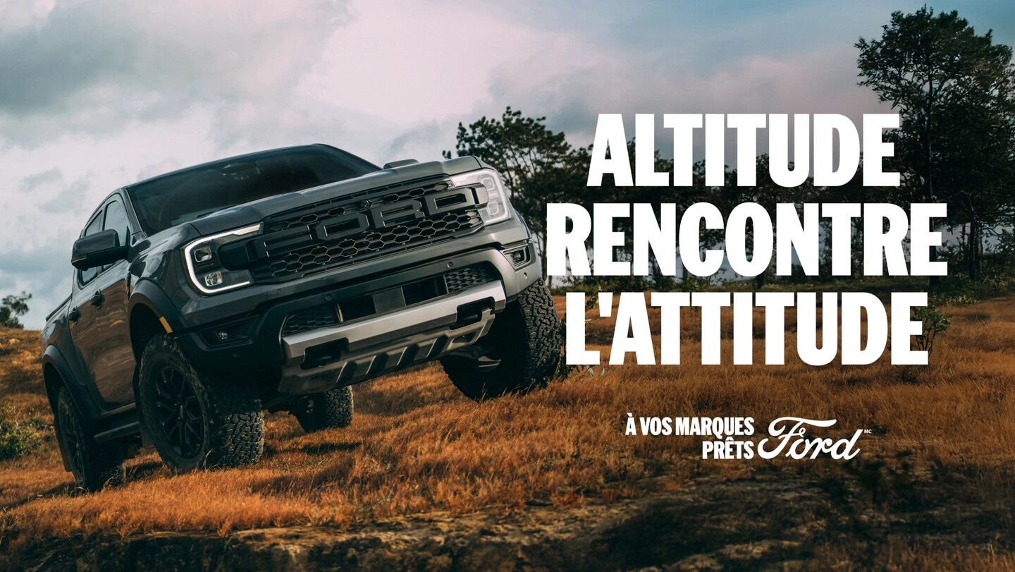 Vue de trois quarts avant d'un Ford Ranger Raptor gris roulant hors route dans un champ ouvert. Altitude rencontre l’attitude. À vos marques, prêts, Ford 