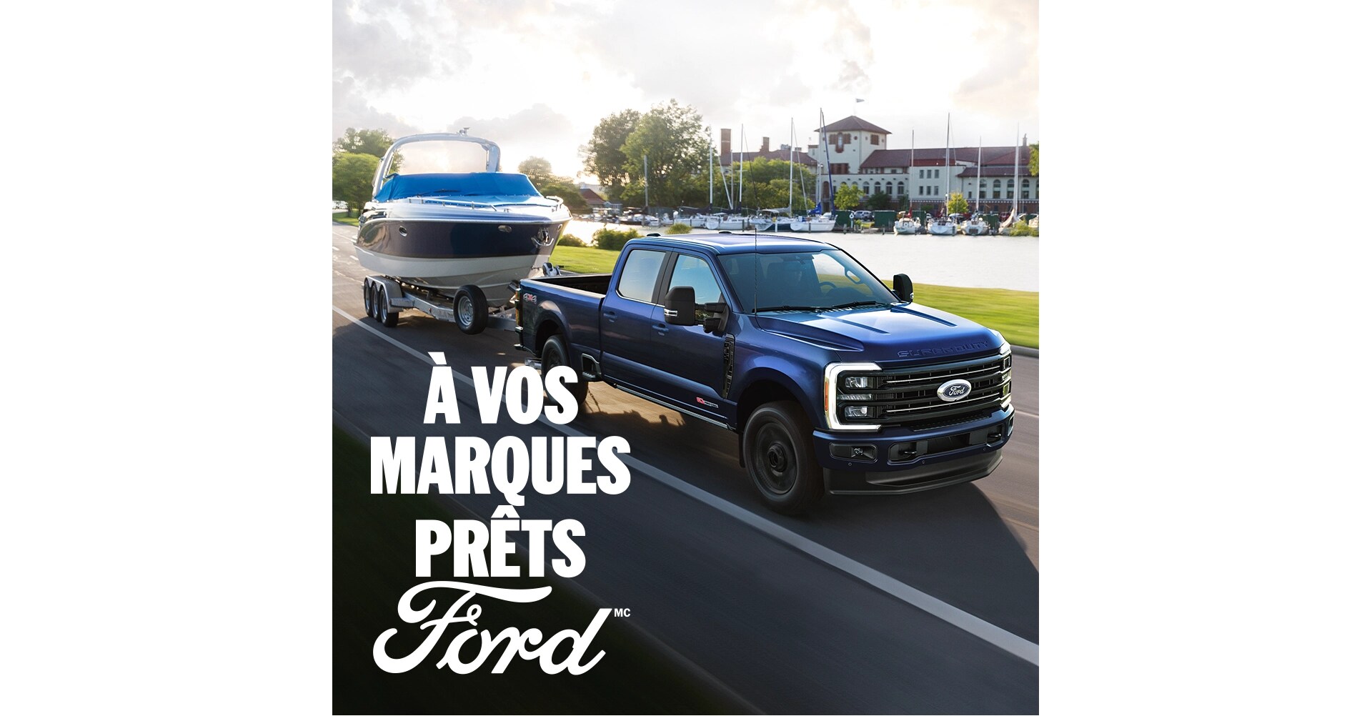 Vue de trois quarts avant d'un Ford Super Duty bleu qui remorque un bateau. Le texte blanc « À vos marques. Prêts.Ford » apparaît dans le coin inférieur droit.  