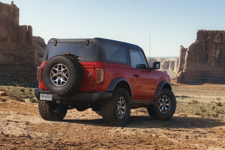 Le Ford® Bronco™ Badlands™ 2023 deux portières en rouge course stationné dans une nature sauvage rocheuse