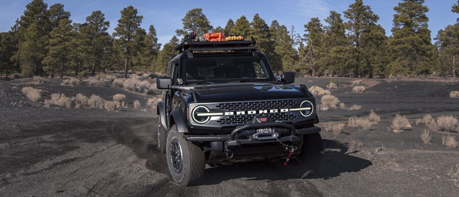 Un Ford Bronco® Badlands® 2 portières 2023 en noir ombre circulant sur un chemin de terre