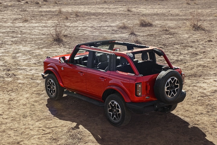 Modèle Ford Bronco® Outer Banks™ 4 portières 2023 avec en rouge piment vernis teint métallisé stationné dans le desert