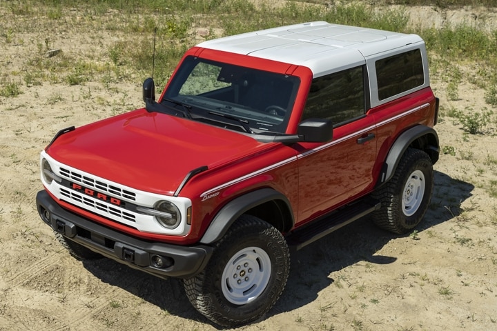 Un modèle Ford Bronco® Heritage 2023 couleur rouge course stationné sur un chemin de terre