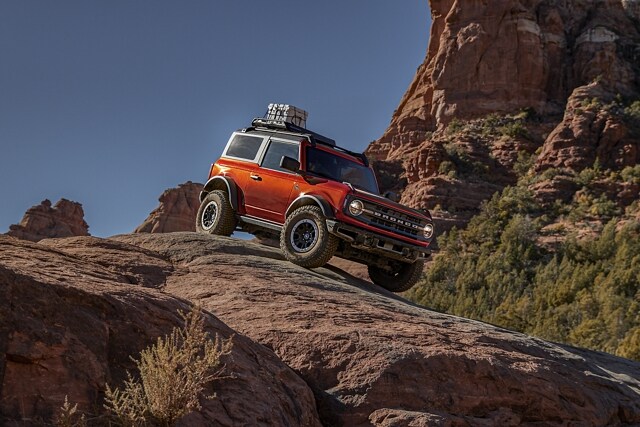 Ford Bronco® Black Diamond™ 2023 à 2 portières en rouge piment avec vernis teint métallisé descendant une pente rocheuse