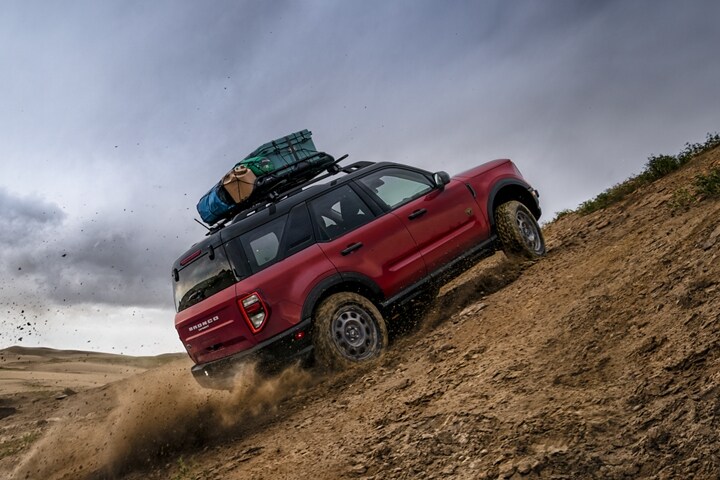 Un Ford Bronco Sport 2021 conduit hors route dans le désert montant une dune de sable