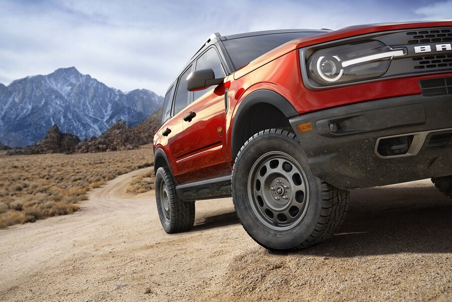 Photo trois quarts du VUS Ford Bronco® Sport 2023 stationné sur une route de terre avec des montagnes en arrière-plan