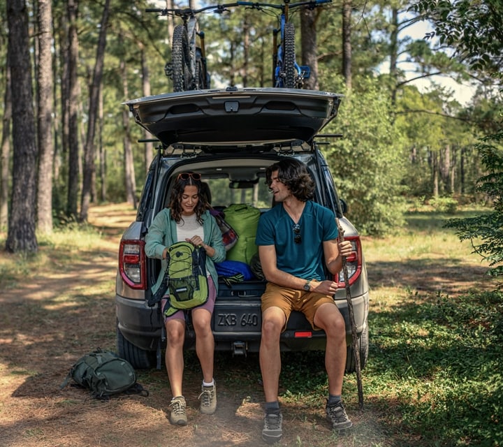 Une femme et un homme assis dans la zone de chargement arrière d’un VUS Ford Bronco® Sport 2024