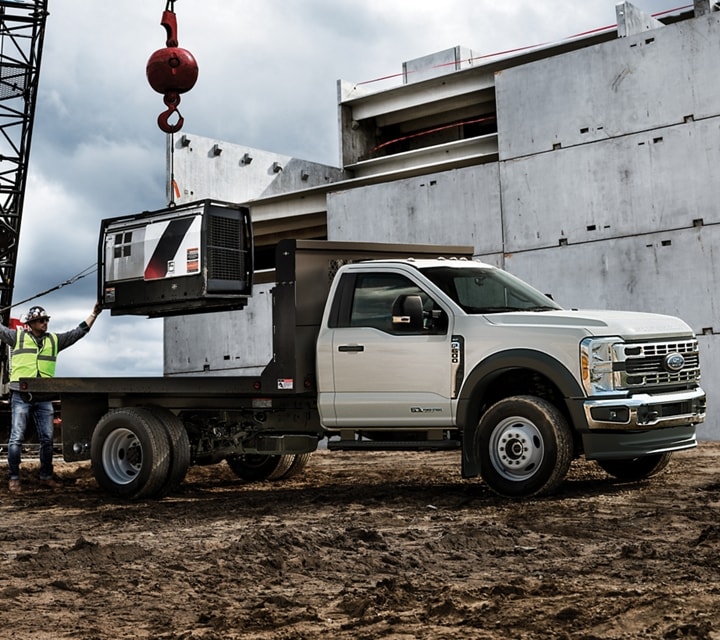 Un Ford Super Duty® à châssis-cabine 2025 sur un chantier de construction avec des équipements en arrière-plan