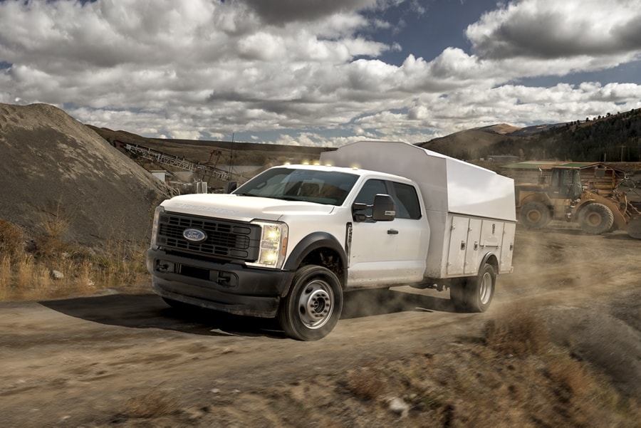 Un Ford Super Duty® F-450 XL 2025 avec caisson utilitaire circulant sur un chantier de terre