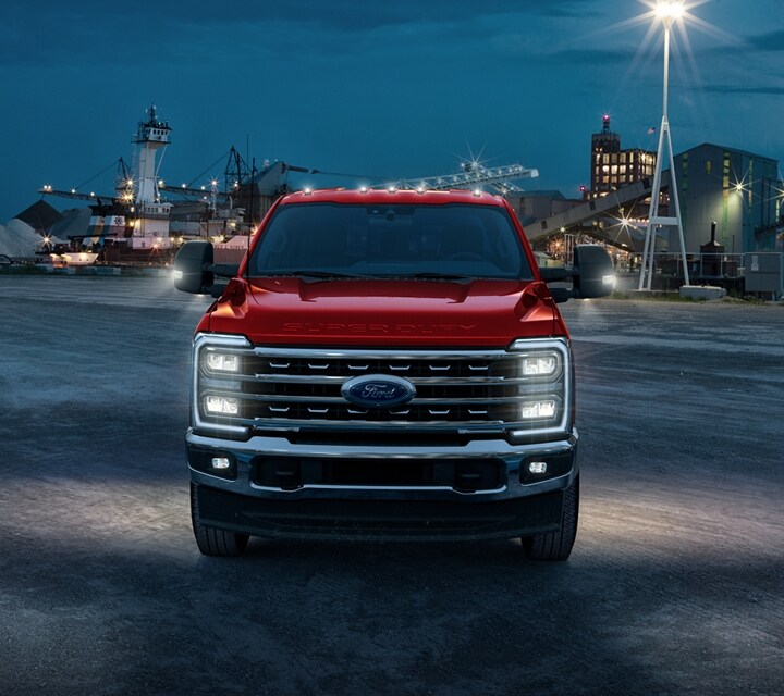 Ford Super Duty® à châssis-cabine 2025 avec phares allumés sur un chantier de construction la nuit
