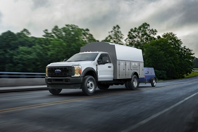 Un Ford Super Duty® 2025 avec une caisse utilitaire remorquant un générateur