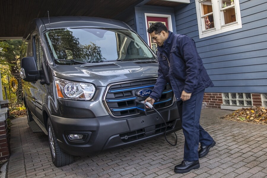 Homme montré en train de charger un fourgon Ford E-Transit™ 2023 dans son entrée