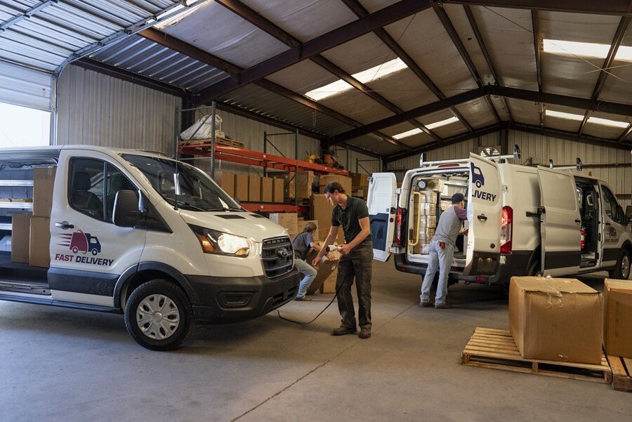 Deux fourgons Ford E-Transit™ 2023 dans un entrepôt, l’une étant chargée, l’autre chargée