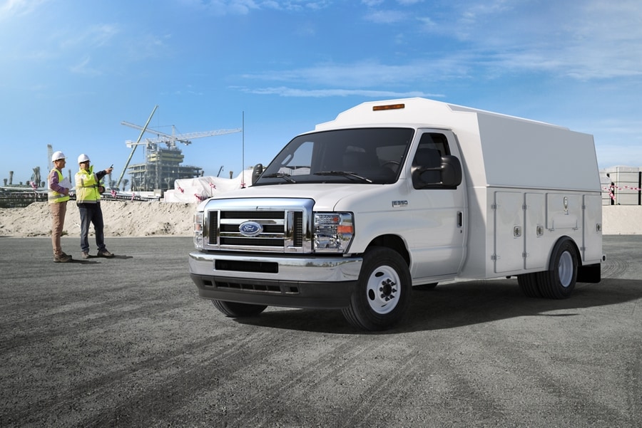 Deux travailleurs de la construction près d’un fourgon tronqué Ford série E 2025 avec carrosserie modifiée d’entrepreneur