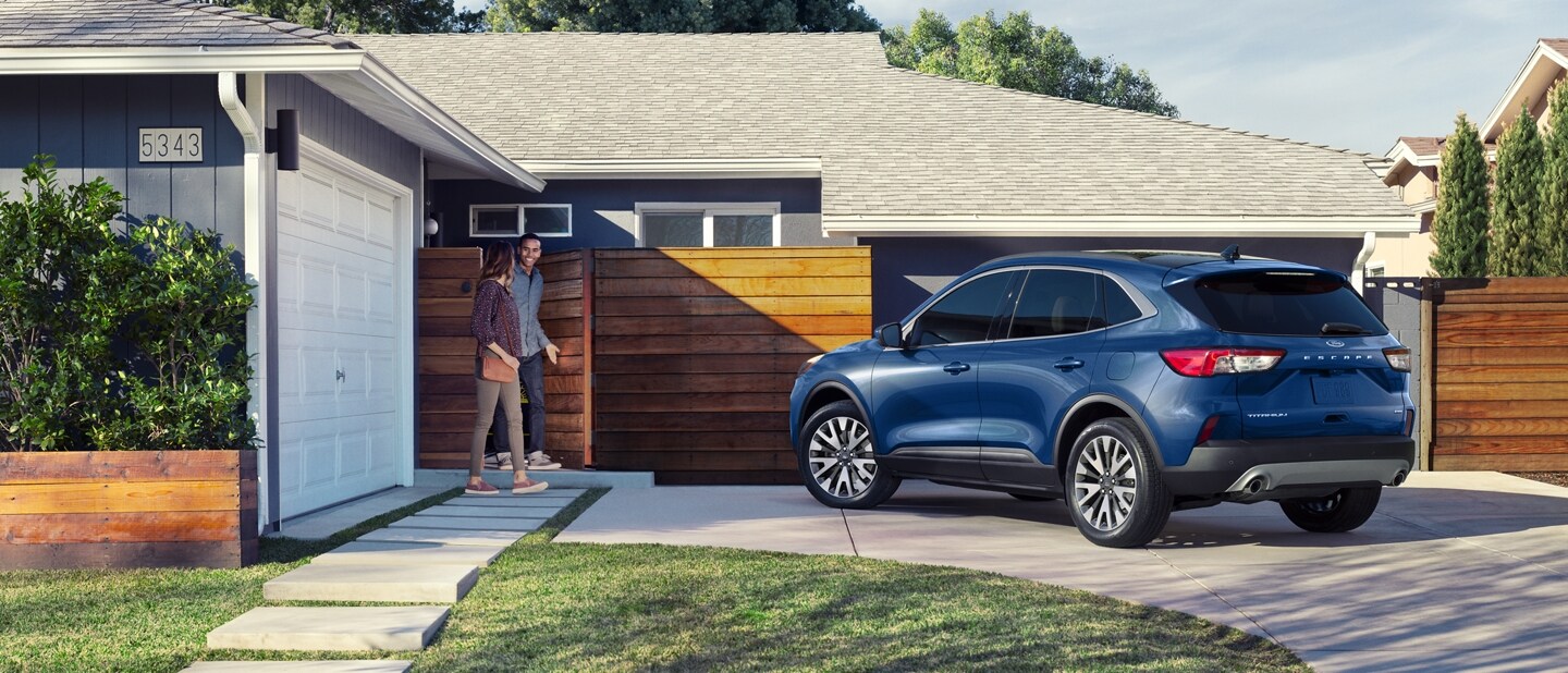 Ford Escape Titanium 2022 de couleur bleu Atlas métallisé stationné dans une entrée résidentielle