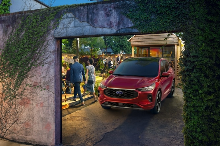 Ford Escape® 2023 en rouge rapide avec vernis teint métallisé stationné la nuit dans une allée pendant la fête