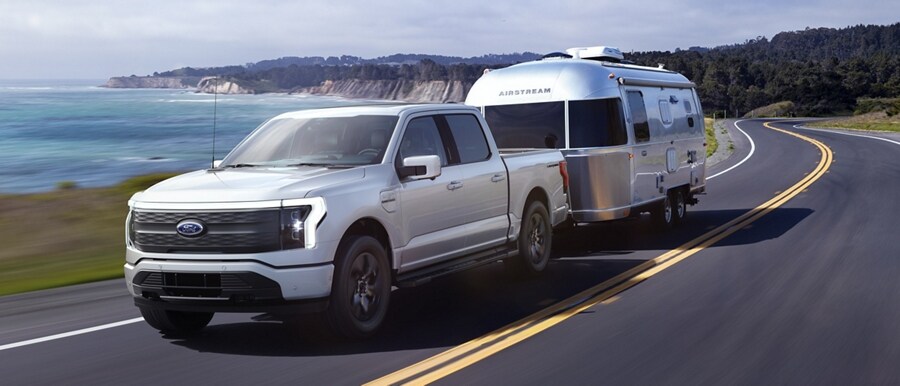Ford F-150® Lightning® 2023 tirant une caravane Airstream près d’un lac