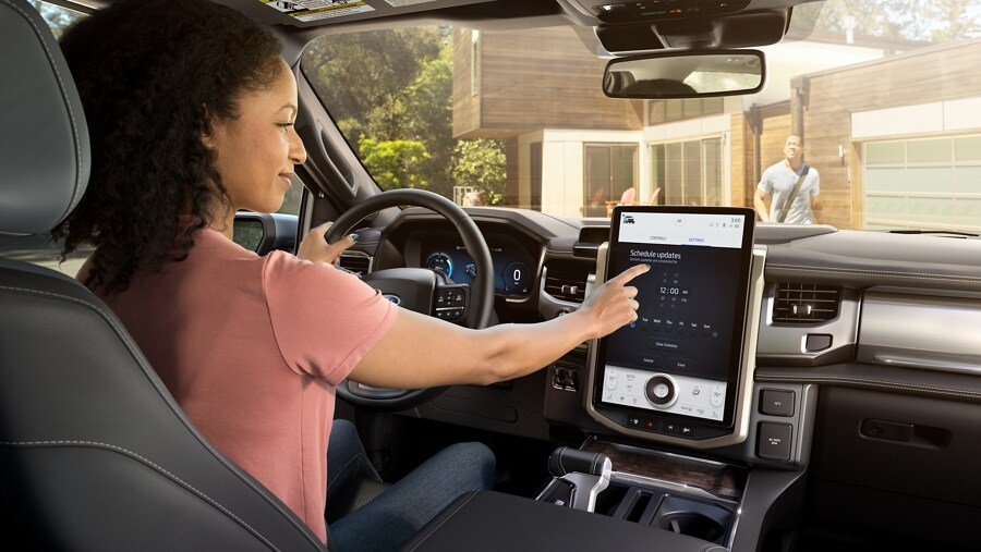 Intérieur du Ford F-150® Lightning® 2023 montrant une femme utilisant les commandes à écran tactile du grand écran central