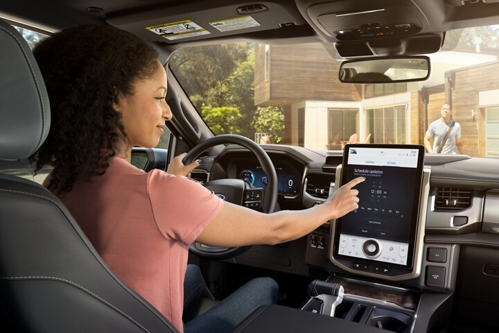 Intérieur d’un Ford F-150® Lightning® 2023 avec une femme interagissant avec l’écran tactile
