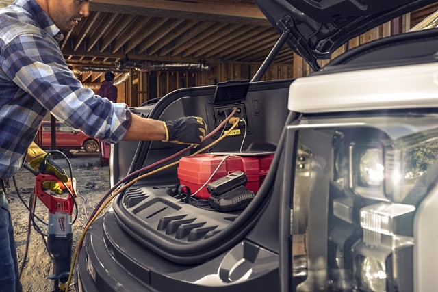 Homme branchant des cordons d’outils électriques au Pro Power embarqué du Ford F-150® Lightning® 2023