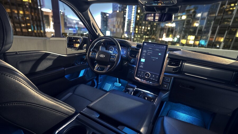 Image intérieure d’un Ford F-150® Lightning® 2023 montrant le grand écran d’affichage central et l’éclairage ambiant de nuit