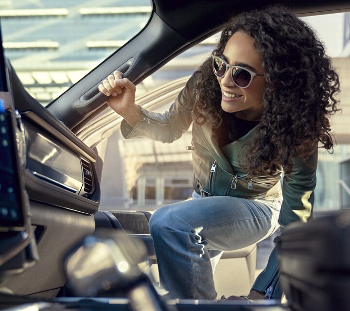 Une femme entrant dans le côté passager d’un Ford F-150® Lightning® 2023 à l’aide de la poignée intérieure