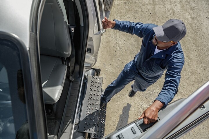 Conducteur entrant dans le Ford F-750 2025 à cabine simple couleur argent emblématique