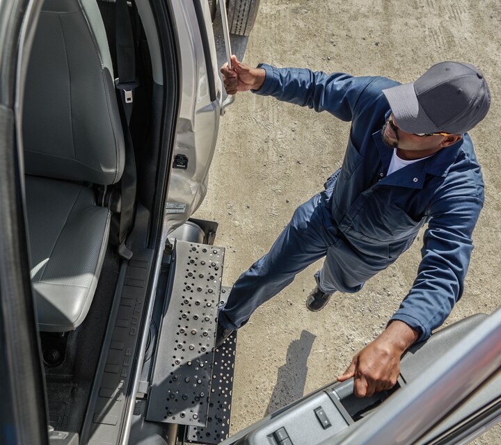 Conducteur entrant dans le Ford F-750® 2026 à cabine simple en argent emblématique
