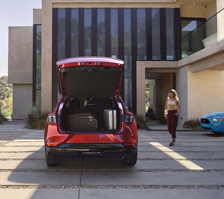 L’arrière de la Ford Mustang Mach-E® 2023 stationnée dans une allée avec une Ford Mustang patrimoniale stationnée à droite