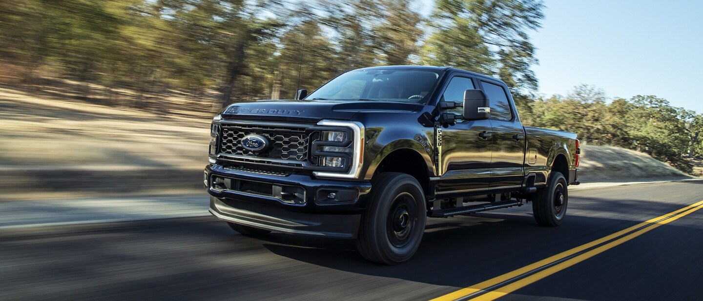 Modèle Ford Super Duty® F-250® XL STX® 2025 avec ensemble décor circulant sur une route pavée