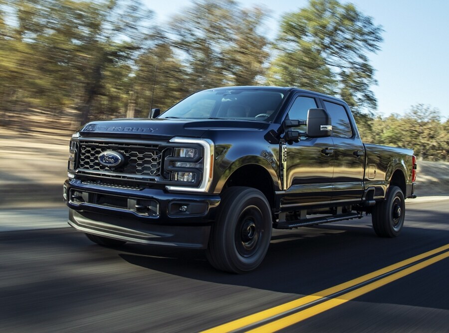 Modèle Ford F-250® Super Duty® STX® 2025 avec ensemble décor circulant sur une route pavée