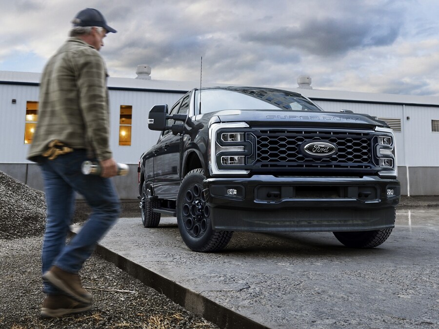 Homme marchant vers un modèle Ford Super Duty® 2025 noir avec ensemble décor