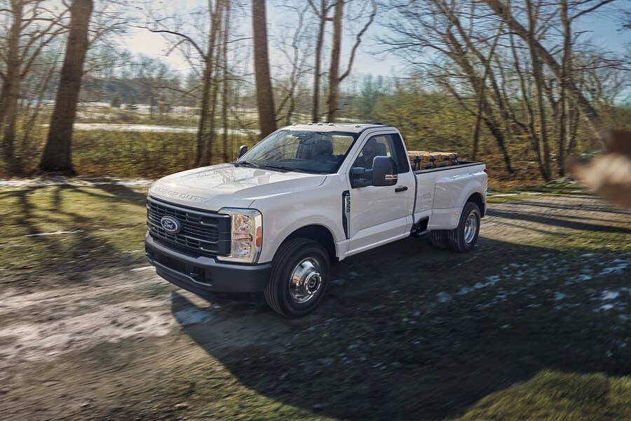 Modèle Ford Super Duty® F-350® XL à RAJ 2025 en blanc Oxford circulant sur un chemin boueux