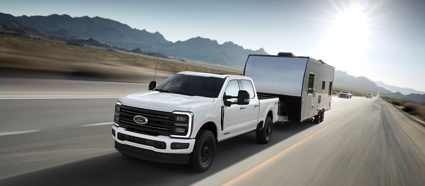Modèle Ford Super Duty® F-350® Platinum® TREMOR™ 2025 en blanc Oxford tirant une caravane