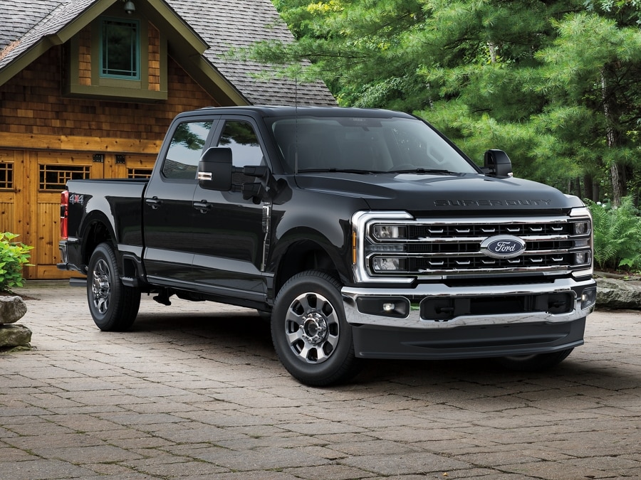 Modèle Ford Super Duty® Lariat 2025 en noir agate stationné dans une entrée