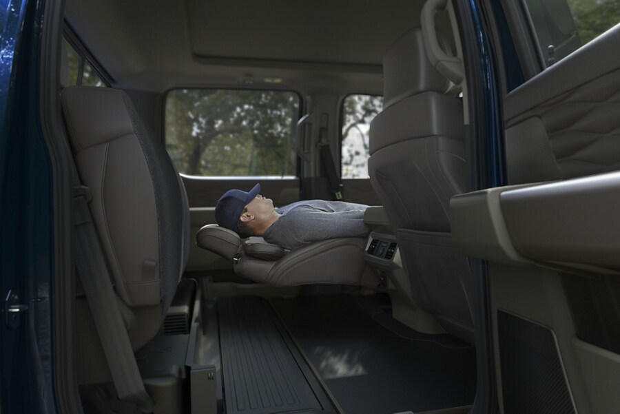 Homme allongé sur le siège avant à inclinaison maximale en option dans un Ford Super Duty® 2025