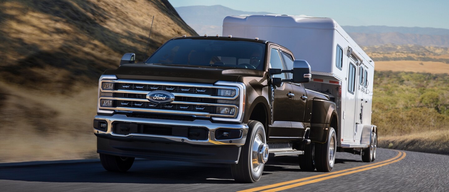 Modèle Ford Super Duty® F-250® TREMOR™ 2025 tirant un tracteur sur une remorque