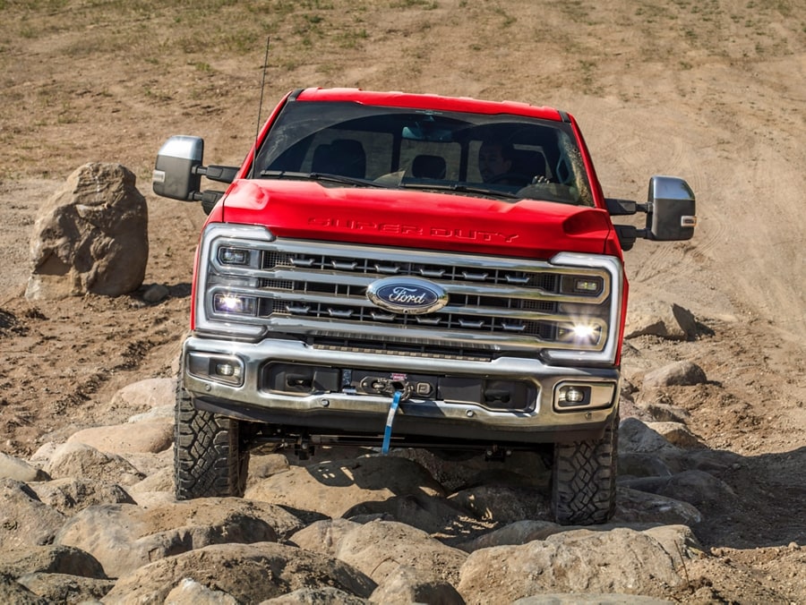 Modèle Ford Super Duty® F-250® TREMOR™ 2025 en rouge rapide circulant sur des rochers dans le désert