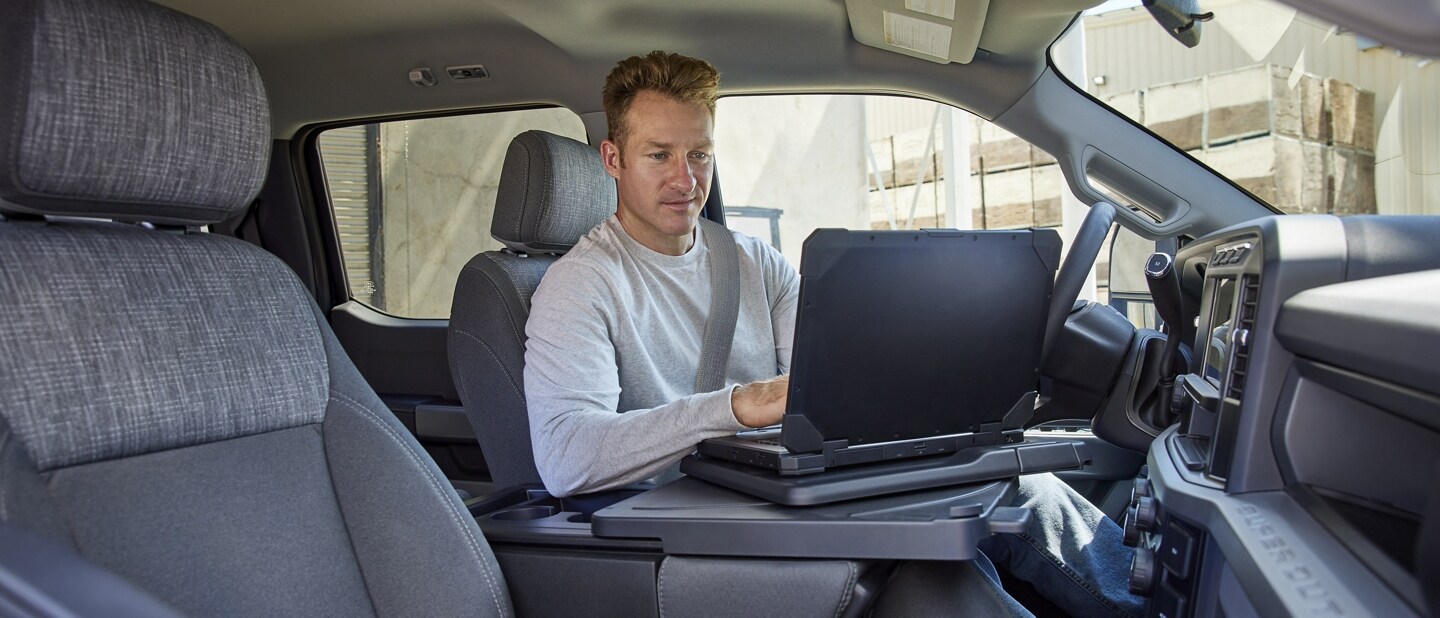 Homme utilisant un ordinateur portable à l’intérieur d’un camion Ford Super Duty® 2025