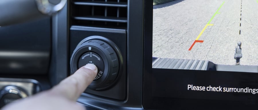 Gros plan d’une personne appuyant sur le bouton Pro Trailer Hitch Assist dans un camion Ford Super Duty® 2023