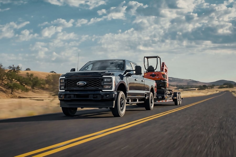 Camionnette Ford Super Duty® STX® 2025 tirant une rétrocaveuse sur une remorque