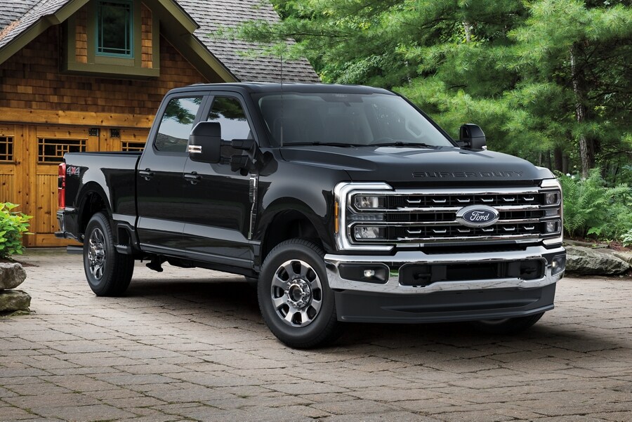 Modèle Ford Super Duty® LARIAT® 2025 en noir agate stationné dans une entrée